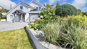 Uma casa moderna de dois andares, com calçada pavimentada e um jardim bem cuidado.