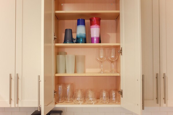 A kitchen cabinet with shelves holding various glassware and containers. - No Shoes Retreat Sandbridge! 2 Bedroom/2 Bath Ocean Retreat! (Virginia Beach)
