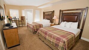 Une chambre d’hôtel avec deux lits, un bureau et une chaise.