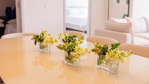 A dining table with three clear glass vases containing flowers. - Edificio Doña Raquel (Panama City)
