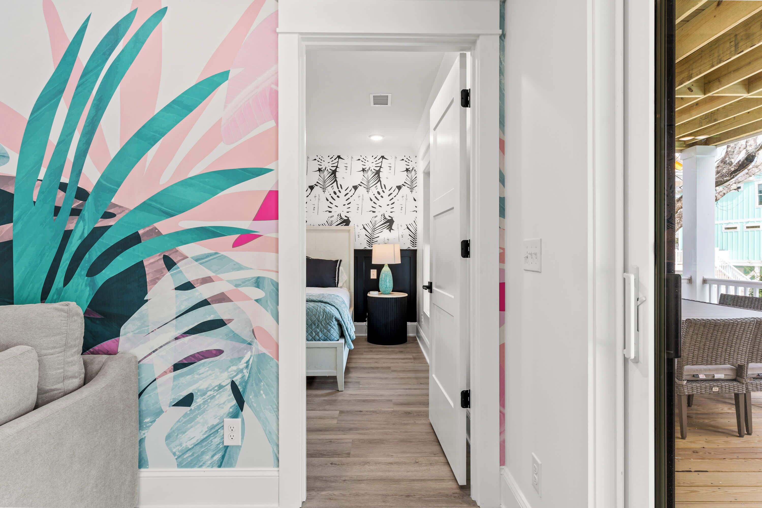 A hallway with a bed, a nightstand, and a lamp.