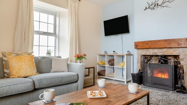 Ein gemütliches Wohnzimmer mit Kamin, einer Couch, einem Couchtisch und einem Bücherregal.