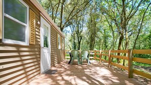 Eine Holzterrasse mit Überdachung, zwei Stühlen und einem Holzzaun.