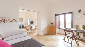 Ein Schlafzimmer mit einem Bett, einem Schreibtisch und einem Stuhl. Außerdem ist ein Schminktisch und eine Heizung vorhanden.