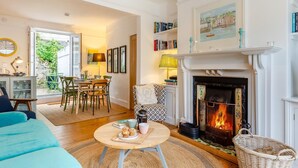 Una sala de estar acogedora con chimenea, comedor y estantería.