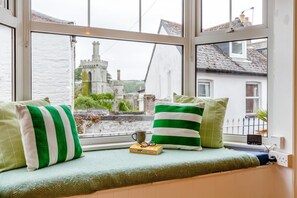 A window seat with cushions, a book, and a mug. - 3 Bed in Fowey (oc-m32343) (Fowey)