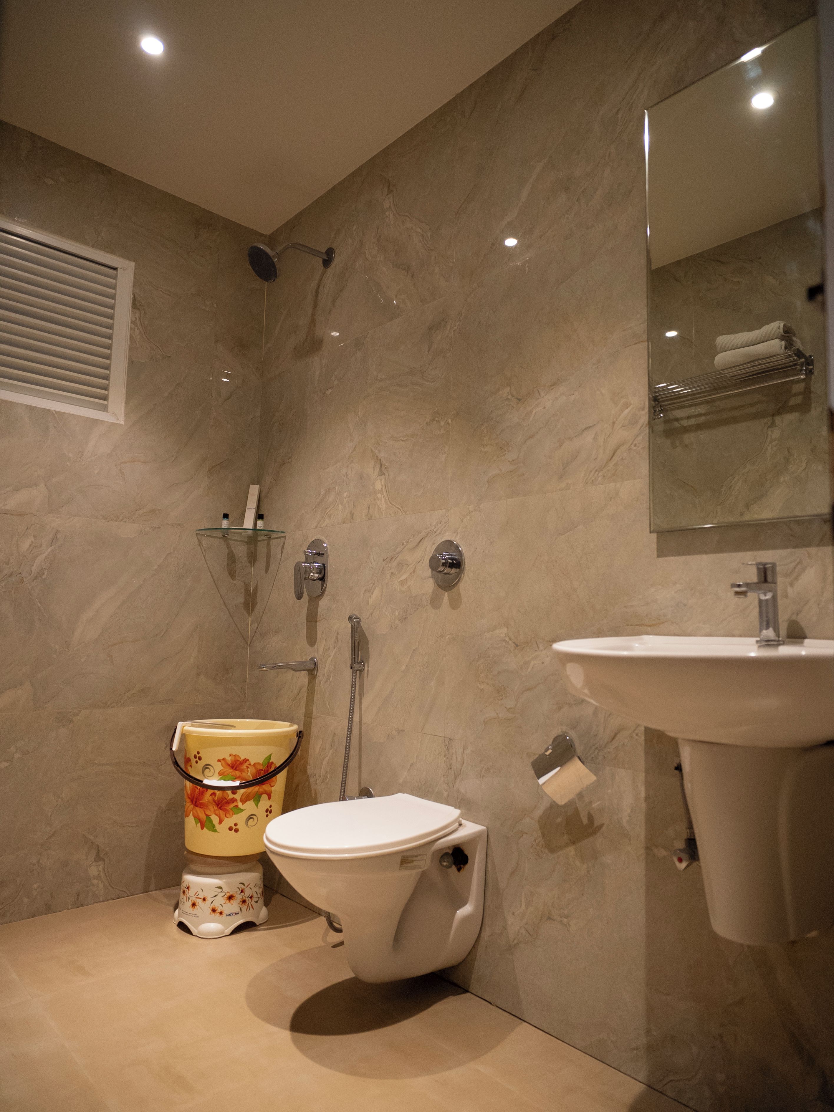 A bathroom with a toilet, shower, and sink.