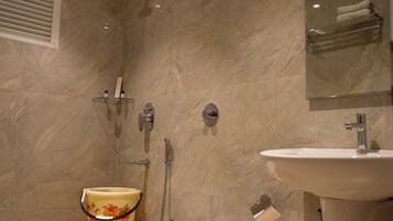 A bathroom with a toilet, shower, and sink.