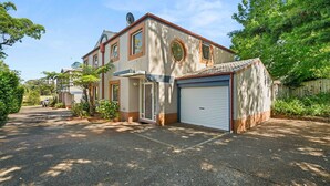 Ein zweistöckiges Haus mit Garage, Satellitenschüssel und Auffahrt zum Eingang.