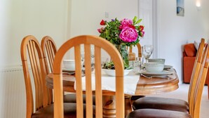 A dining table set with chairs, a vase of flowers, and a white tablecloth. - 2 Bed in Looe (oc-g32529) (Looe)