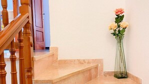 A staircase with a wooden handrail and a vase with flowers on the landing. - Charming Two-Story Villa with Private Pool and Garden in Miami Platja, Close to Catalan Coast (Miami Playa)