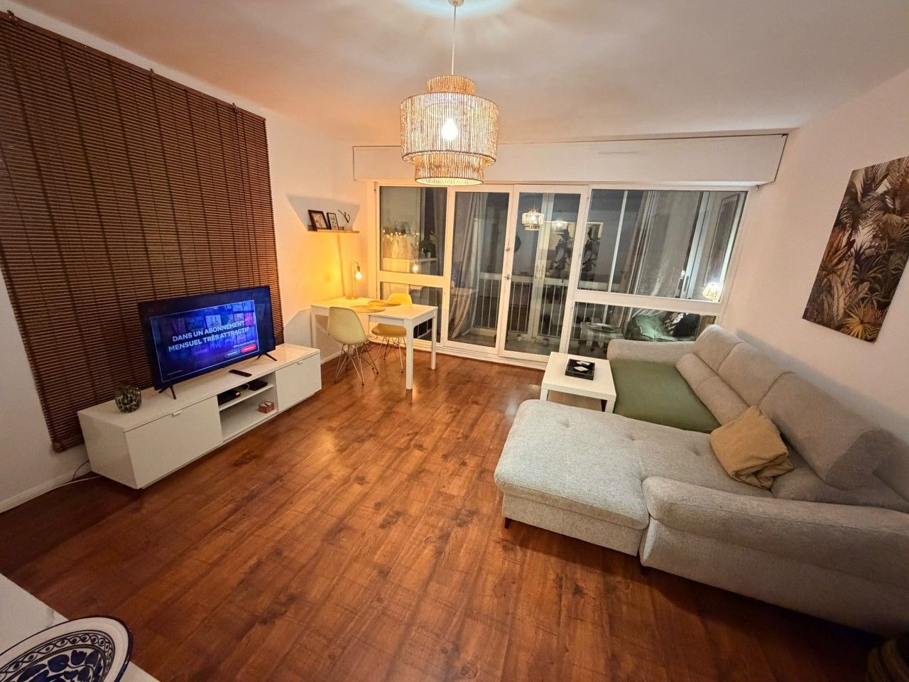 A living room with a television, a sofa, a table, and a chair.
