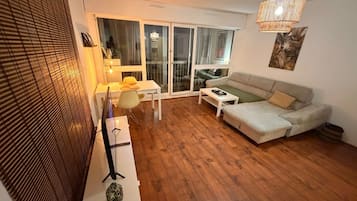 Ein modernes Wohnzimmer mit einer Couch, einem Couchtisch und einem Essbereich mit Tisch und Stühlen.