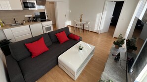 Una sala de estar moderna con un sofá seccional, una mesa de centro y un televisor.
