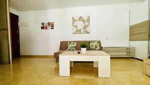 Un salón moderno con un sofá marrón, una mesa de centro blanca y un adorno en la pared.