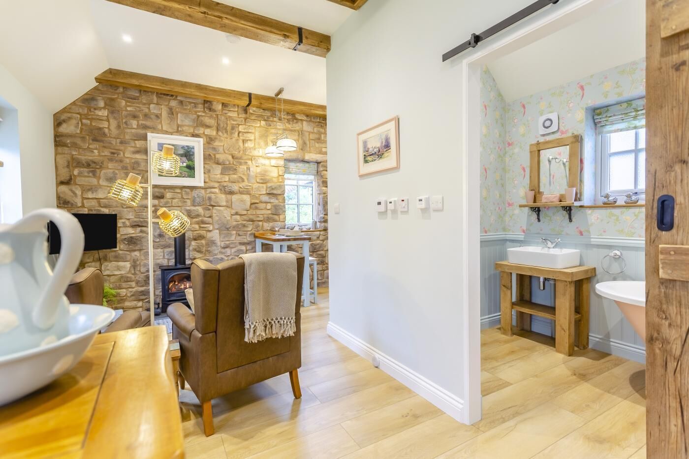 Un salon chaleureux avec un mur en pierre, une cheminée et un coin repas.