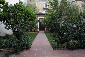 Un camí que condueix a un edifici amb entrada enrajolada.