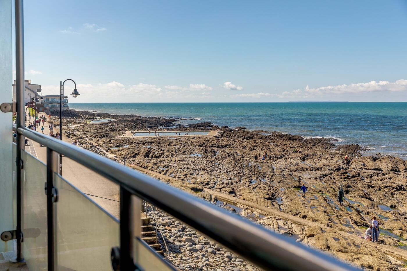 Ein felsiger Strand mit freiem Blick auf das Meer und einem Pfad zum Wasser.