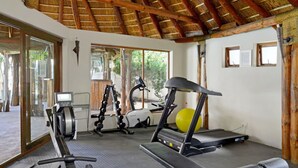 A gym with cardio equipment, a treadmill, and a stationary bike. - Modern Sea Point Oasis | Garden, Pool, BBQ & Gym (Cape Town)