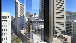 Un edificio moderno de gran altura, con un llamativo diseño arquitectónico y fachada de vidrio, y vistas a la ciudad.