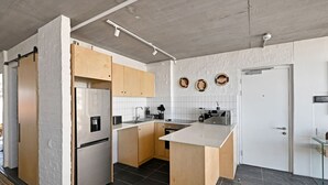 Eine moderne Küche mit weißen Ziegelwänden, Holzschränken und einer zentralen Kochinsel.