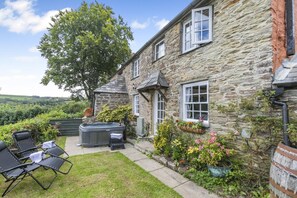 A stone house with a hot tub, outdoor seating, and a garden. - 2 Bed in Liskeard (oc-t32876) (Duloe)