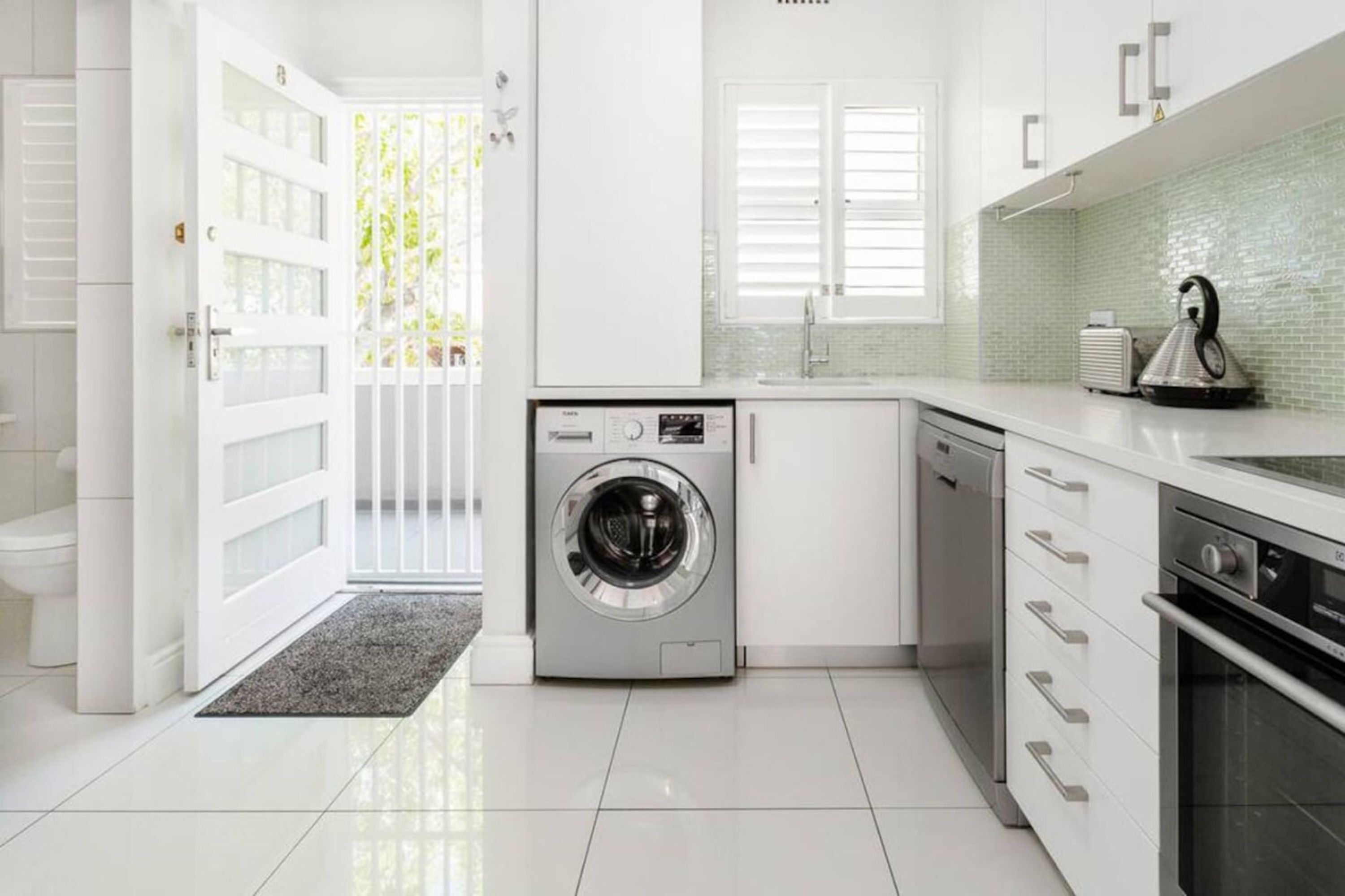A modern kitchen with a built-in washer, a sink, and a stove.