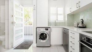 Uma cozinha moderna com máquina de lavar embutida, pia e fogão.