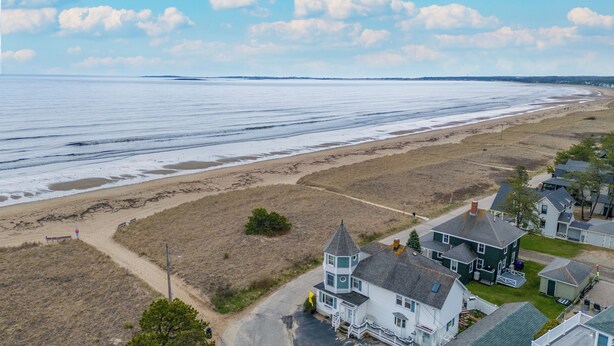 Une zone résidentielle côtière avec des maisons, une plage et un ciel dégagé.