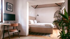 Een slaapkamer met een bed, een bureau en een stoel.