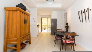 Een moderne keuken met een eethoek, houten keukenkastjes en een zwart hanglamp.