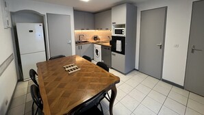 Een kleine keuken met een magnetron, oven en wasmachine.