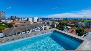 En swimmingpool med udsigt over byens skyline og havet.