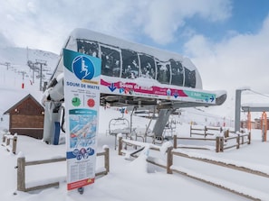 Eine schneebedeckte Sesselbahn mit Schildern, die 'Soum de Matte' und 'St. Lary 1700' anzeigen.