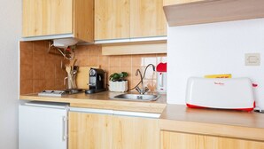 Una cucina con mobili in legno, una macchina da caffè, un tostapane e un lavello.