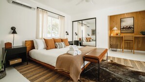 Une chambre moderne avec un grand lit, un bureau et un miroir.