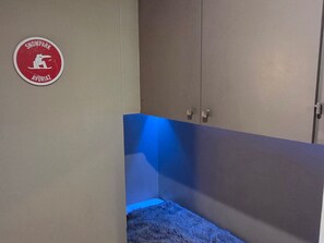 Une pièce avec un lit, une armoire et un panneau accroché au mur.
