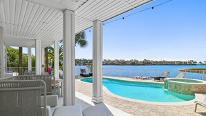 A covered outdoor area with a pool, seating, and a view of the sea. - 🏖️🎮🎲Lakefront | Private Pool | A Gamer's Getaway | Destin to Relax (Destin)