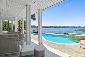 A covered outdoor area with a pool, seating, and a view of the sea. - 🏖️Lakefront | Private Pool | Pet Friendly | Game Room | Destin to Relax🏖️ (Destin)