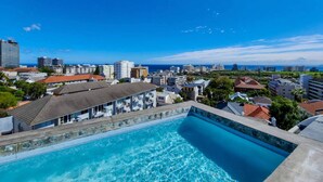 A swimming pool with a view of a cityscape and the ocean. - One Bedroom | Green Point | Spacious (Cape Town)
