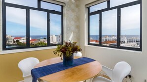 Zona pranzo con tavolo, sedie e un vaso di fiori.