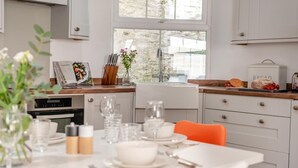 Een moderne keuken met witte kastjes, een houten aanrechtblad en een eethoek gedekt voor een maaltijd.
