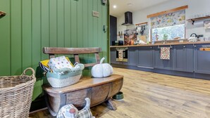 A kitchen with a wooden bench, a basket, a pumpkin, and a dog figurine. - 2 Bed in Invergordon (oc-c33073) (Invergordon)
