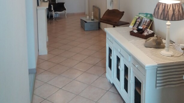 A spacious hallway with a reception desk, a seating area with a brown chair, and a lamp on a side table. - B & B CELESTE BEDONIA 5 minutes from town center (Bedonia)