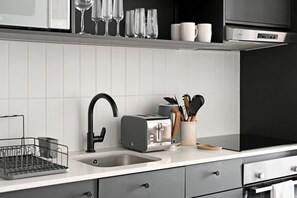 Eine moderne Küche mit Spüle aus Edelstahl, einem Toaster und einem Besteckhalter.