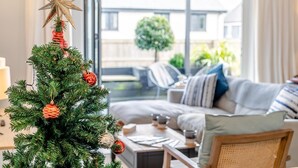 A modern living room with a Christmas tree, a star ornament, and a sofa with cushions. - 3 Bed in Fowey (oc-s33234) (Fowey)