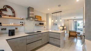 A modern kitchen with a central island, built-in appliances, and pendant lighting. - 3 Bed in Fowey (oc-s33234) (Fowey)