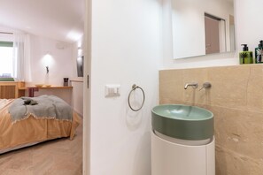 Un baño moderno con un lavamanos grande, un aro para toallas y un espejo sobre el lavamanos.