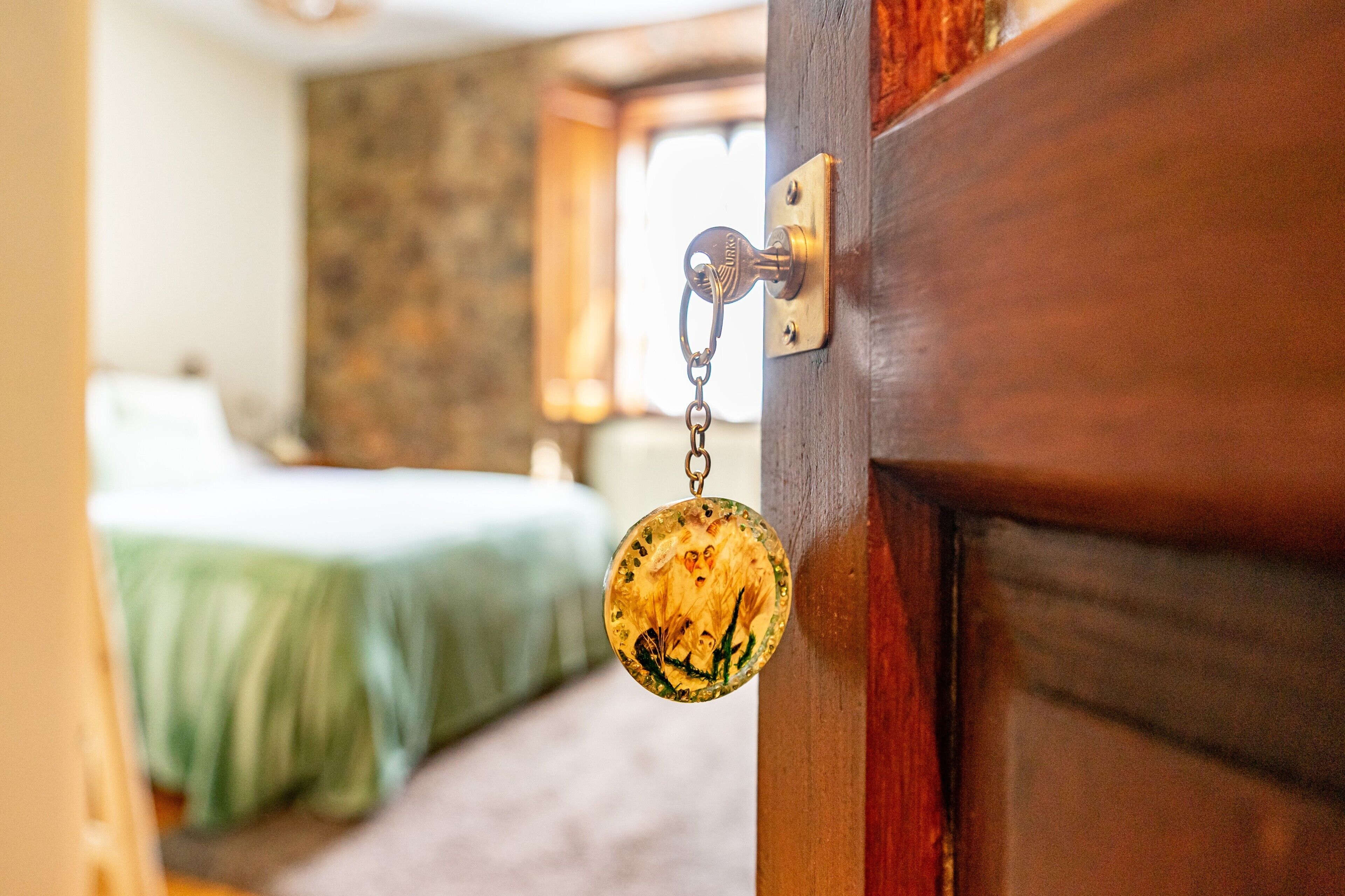 A wooden door with a brass handle and a keychain.