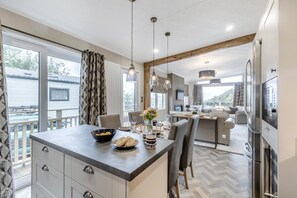 A modern kitchen with a dining area, large windows, and a view of the outside. - 2 Bed in Tresaith (oc-p33407) (Tresaith)